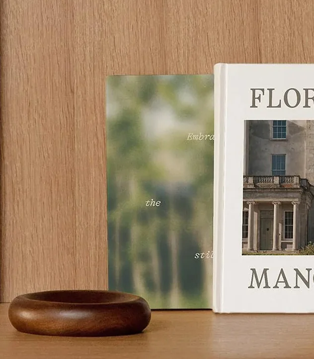 A monograph on Florida houses propped against oak, beside a turned wooden bowl.